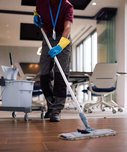 Close up of black female cleaner mopping office floors.